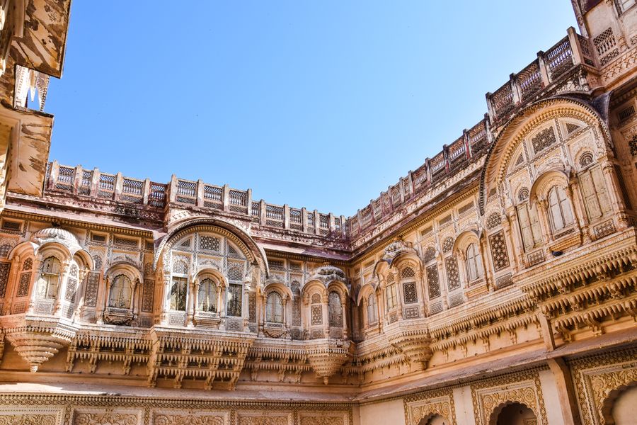 Explore the detailed carvings of a historic Indian monument under a bright blue sky.