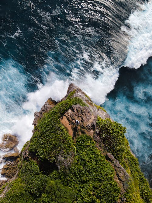 Birds Eye View of a Man Standing on the Rock and Rough Sea