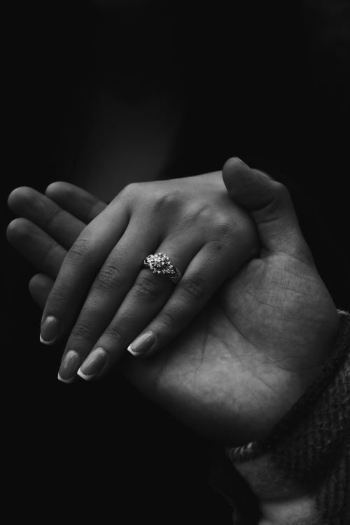 Free Intimate black and white close-up of hands, featuring a romantic gesture with a diamond ring. Stock Photo