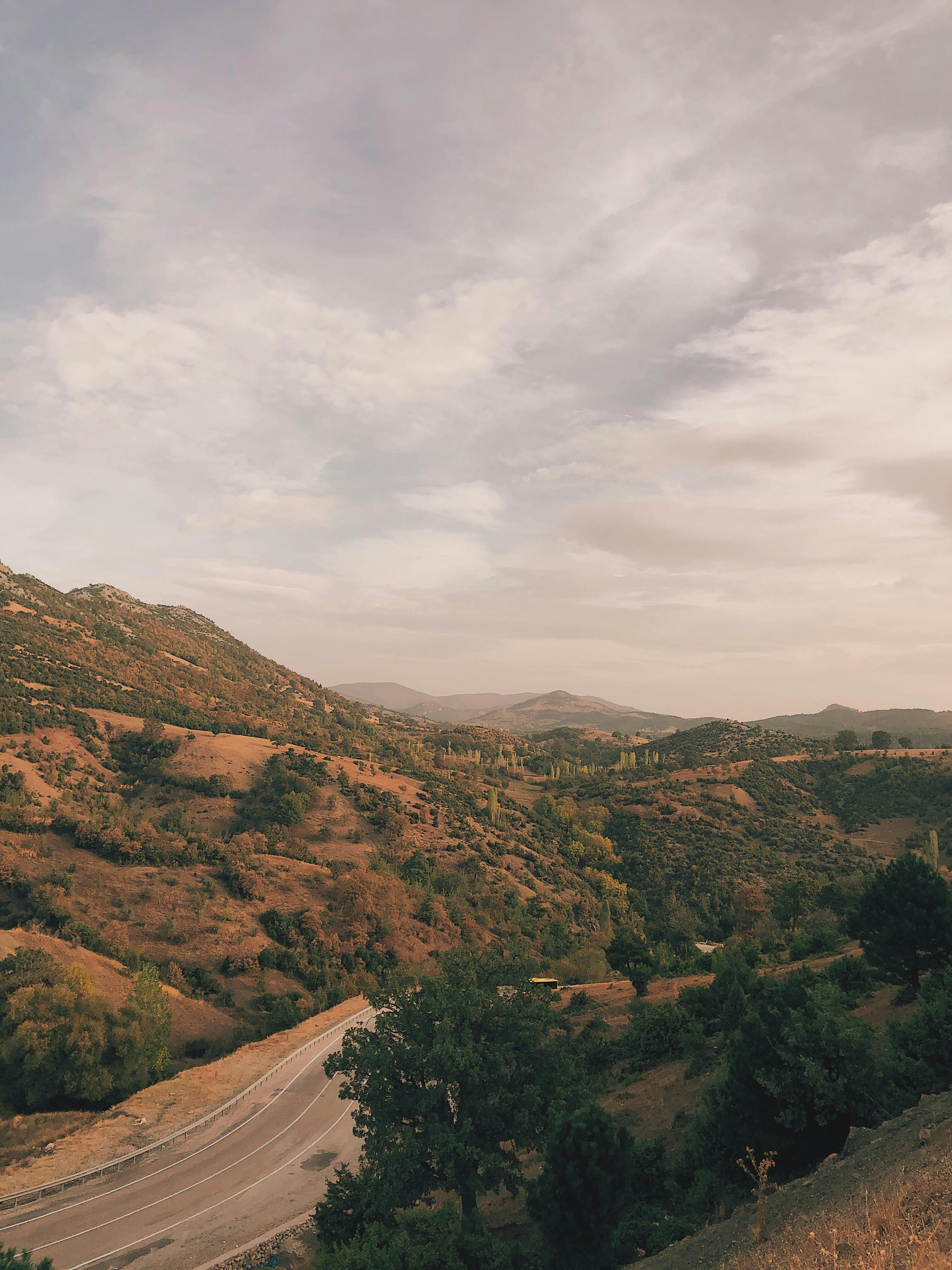 Beautiful landscape of hills and winding road in Gürsu, Türkiye during sunset.