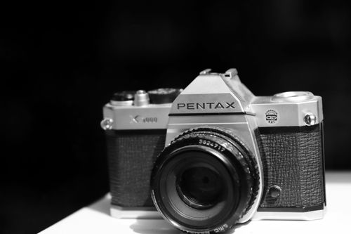 Free Classic Pentax film camera in a striking black and white portrait. Stock Photo