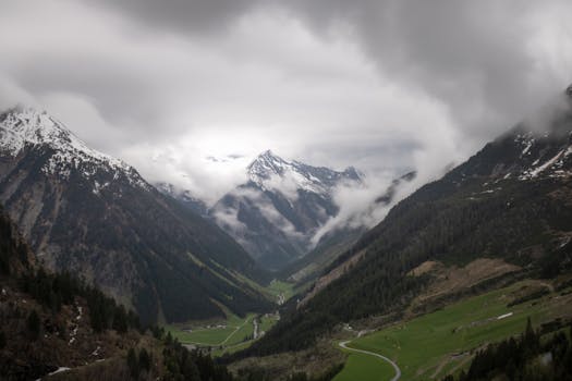 Dramatic view of the snow-capped Alps and lush valley in Zillergrund, Austria.