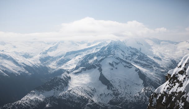 Scenic view of snow-covered mountains in Hintertux, Tirol, Austria, with misty clouds.