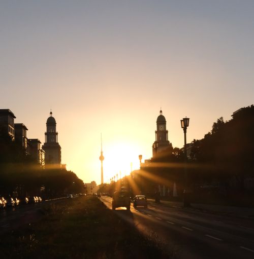 Free Sunset view of Berlin's skyline featuring the Fernsehturm and urban streetscape. Stock Photo