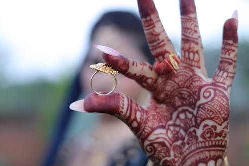 Henna Tattoo on Hand of Woman Holding Ring