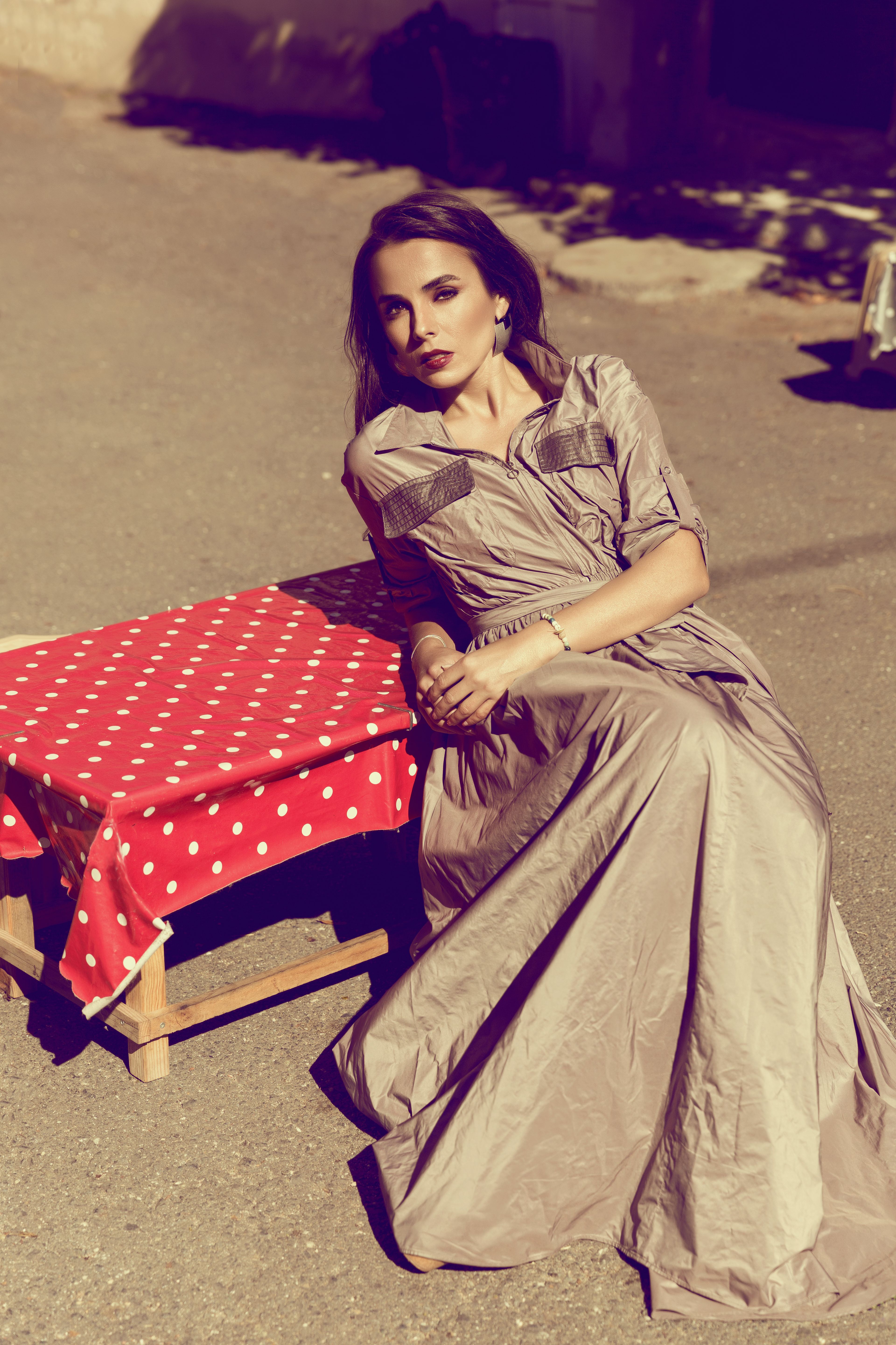 Stylish woman in elegant attire posing outdoors under sunlight in İstanbul.