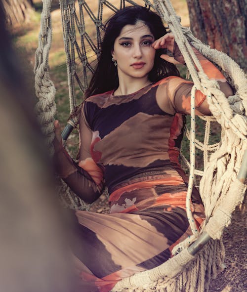 Young Woman in a Dress Sitting in a Hammock Chair 