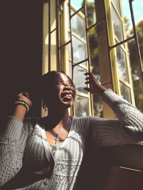 Smiling Woman Sitting by the Window 