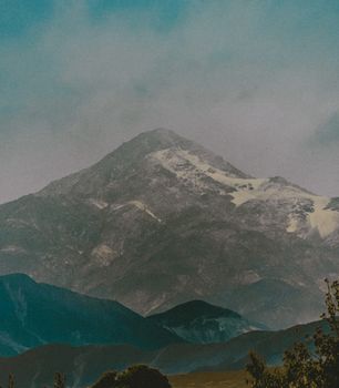 A beautiful, fog-covered mountain scene with snow-capped peaks, creating a majestic and serene view.