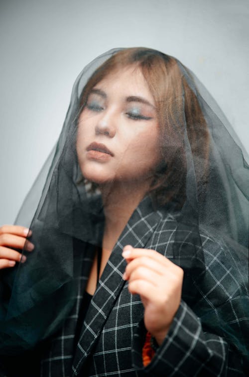 Studio Shot of a Young Woman Wearing Tulle Fabric on Her Head 