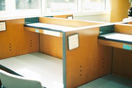 Empty wooden cubicles in a sunlit office — photo by Yuqi Chen on Pexels