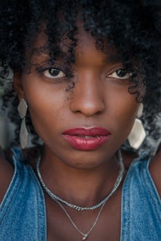Intimate close-up portrait of a woman wearing denim and bold red lipstick.