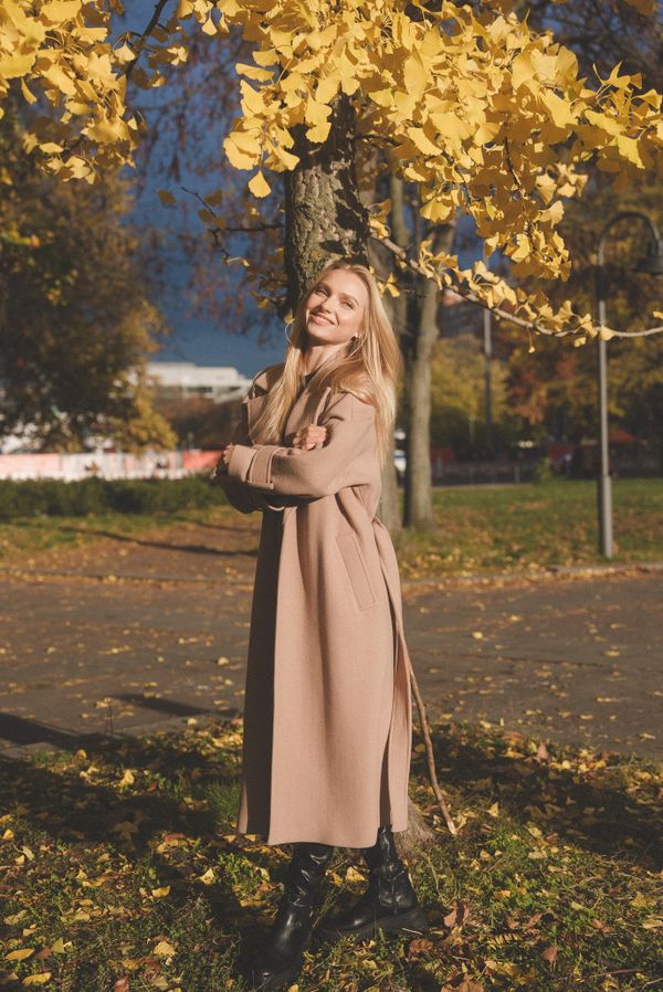 Woman in oversized beige wool coat with knee-high boots