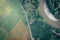 航拍图像令人惊叹，展示了充满活力的景观，其中拥有郁郁葱葱的农田和蜿蜒的河流弯道