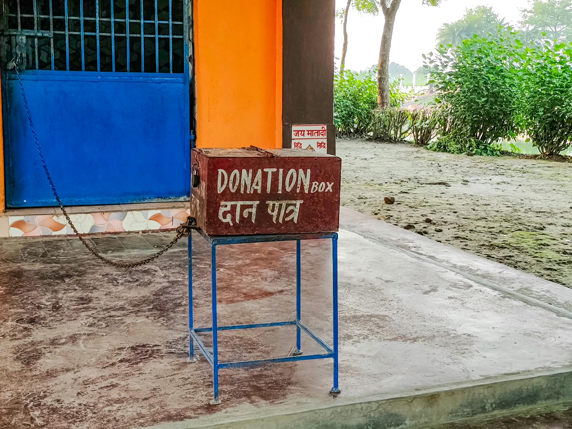 A donation box sits on the ground outside a building