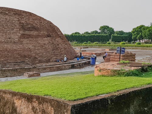 The ancient brick structure is surrounded by grass