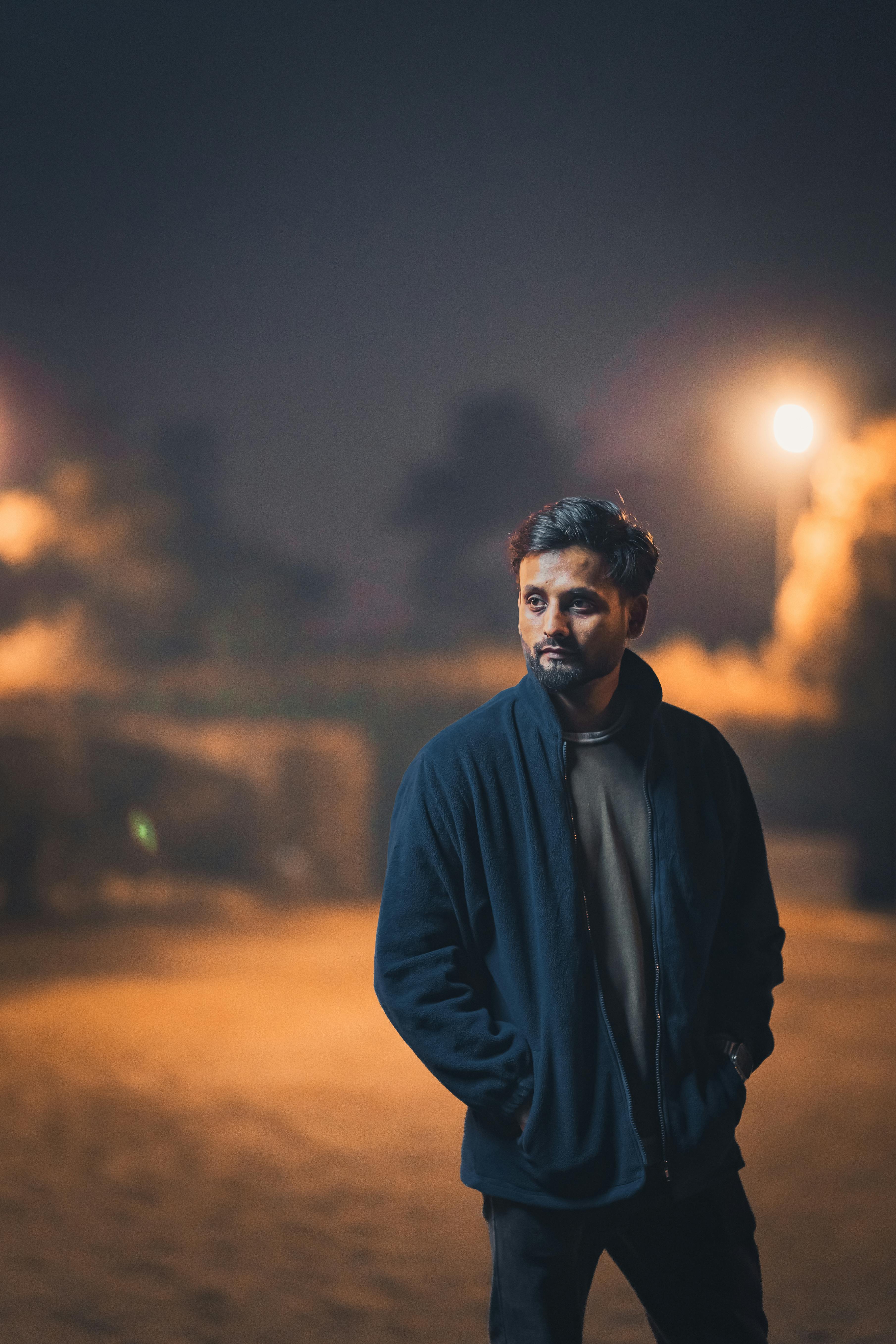 Man Sitting on the Bench under a Streetlamp at Night · Free Stock Photo