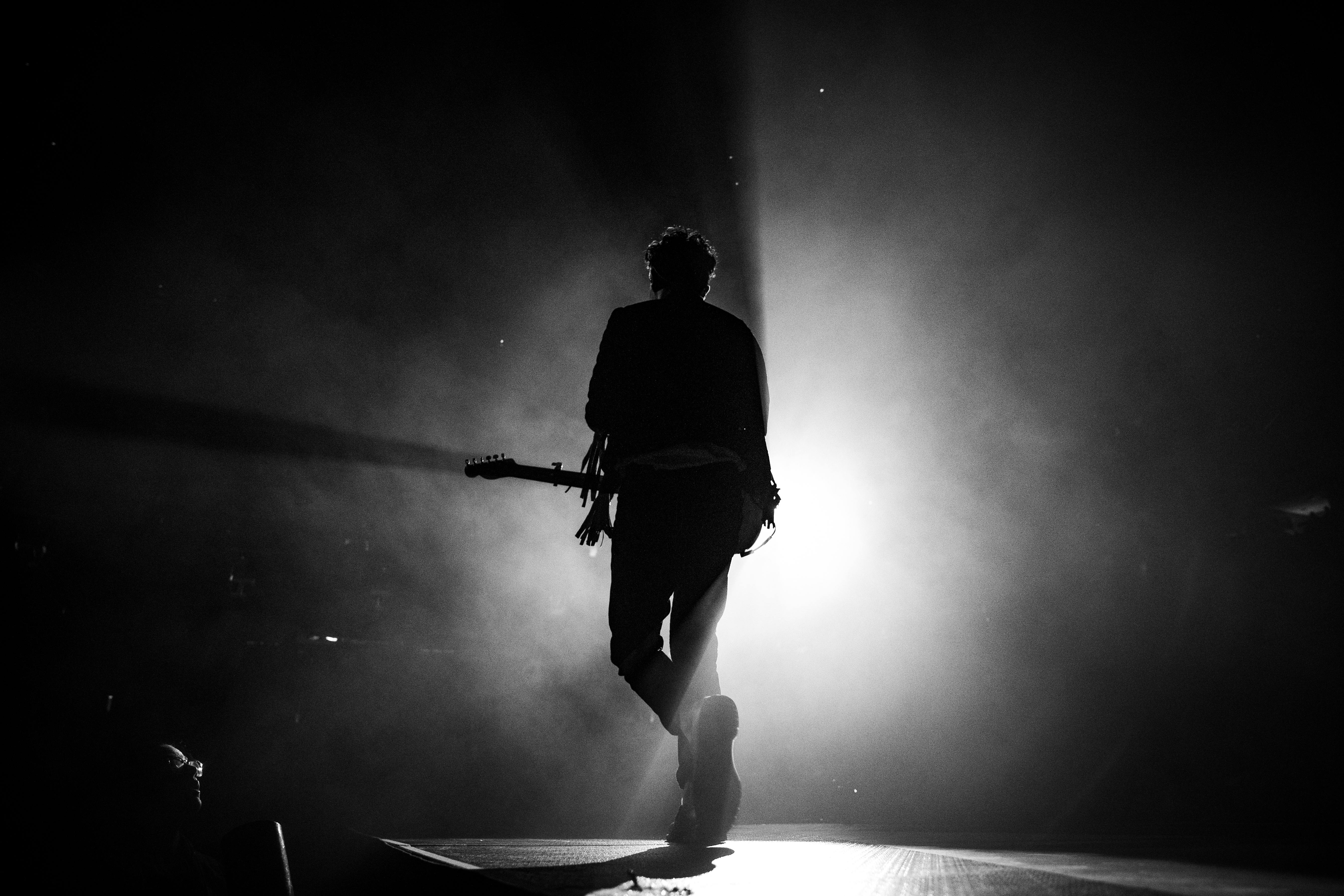 silhouette photo of man singing on stage