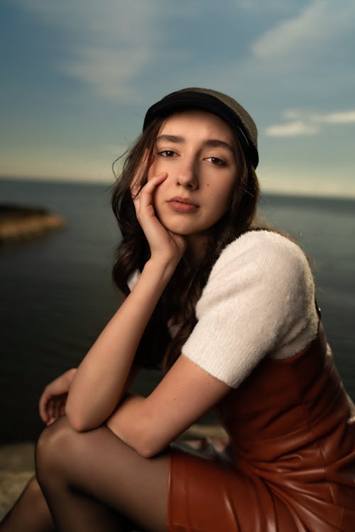 Free A woman in a hat sitting on a rock Stock Photo