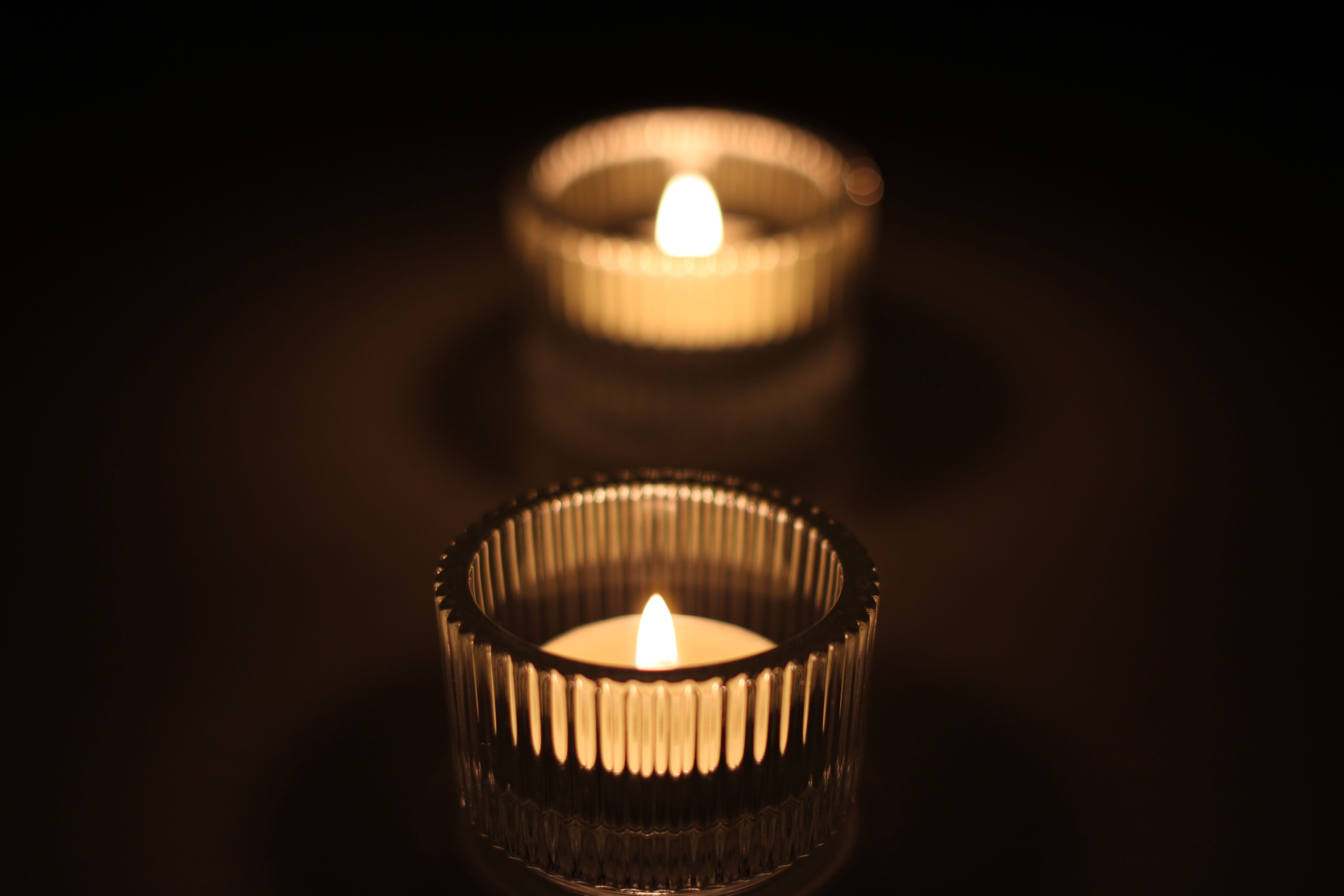 Close-up of glowing candle in a dark setting, creating a soothing ambiance.