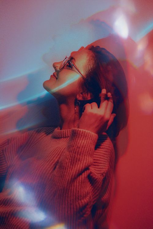 Free Captivating portrait of a woman with glasses in a double exposure effect and colorful lighting. Stock Photo