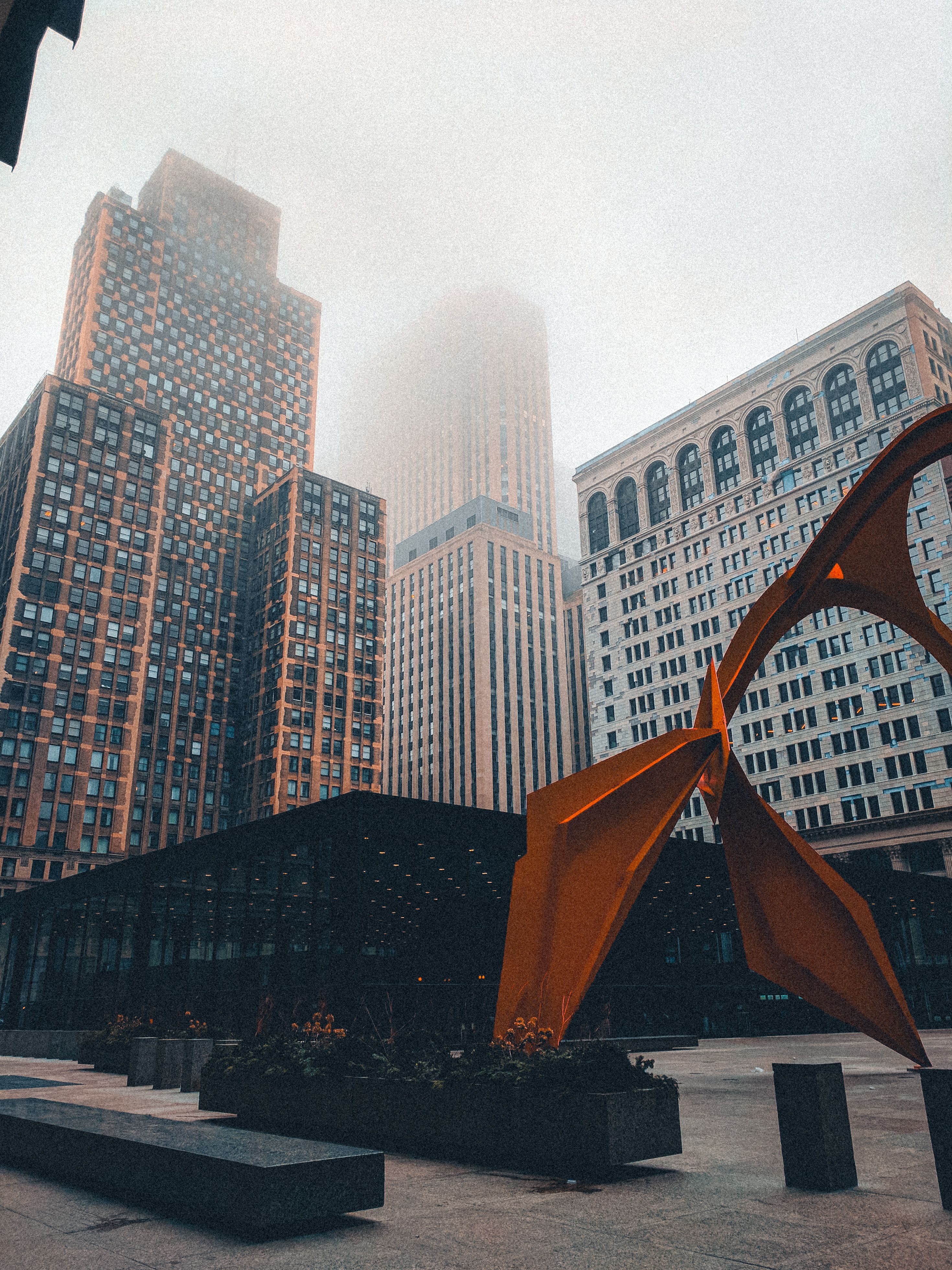 Captured in Chicago, this image shows towering skyscrapers and Calder's Flamingo in misty weather.