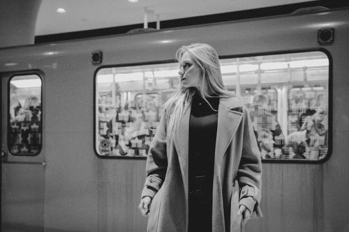 Free A fashionable woman stands confidently at a metro station, showcasing urban style. Stock Photo