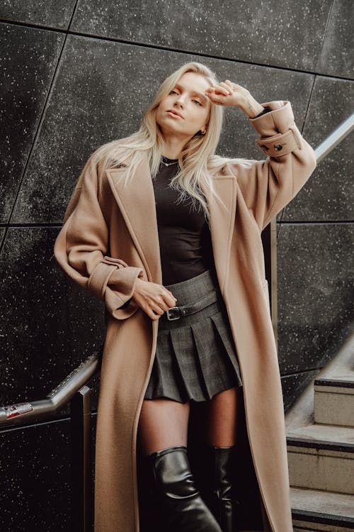 Woman Posing in a Skirt and a Coat on a Staircase