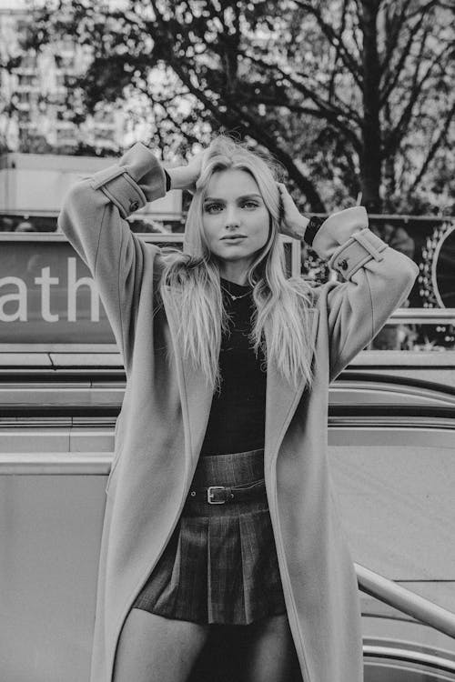 Woman in a Coat and a Skirt with her Hands in her Hair