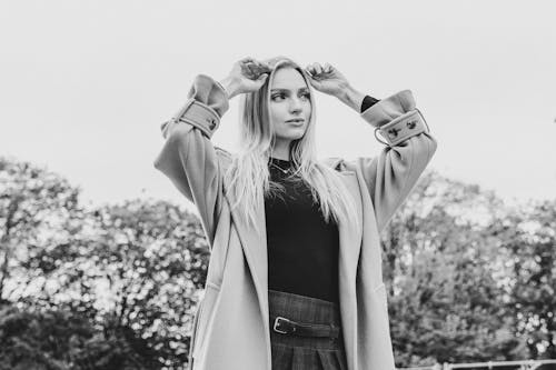 Woman Posing in a Coat with Raised Arms in Black and White