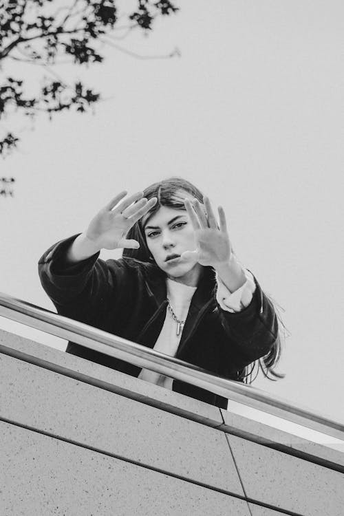 Woman Standing behind Railing in Black and White