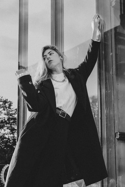 Model in Coat Standing by Windows in Black and White