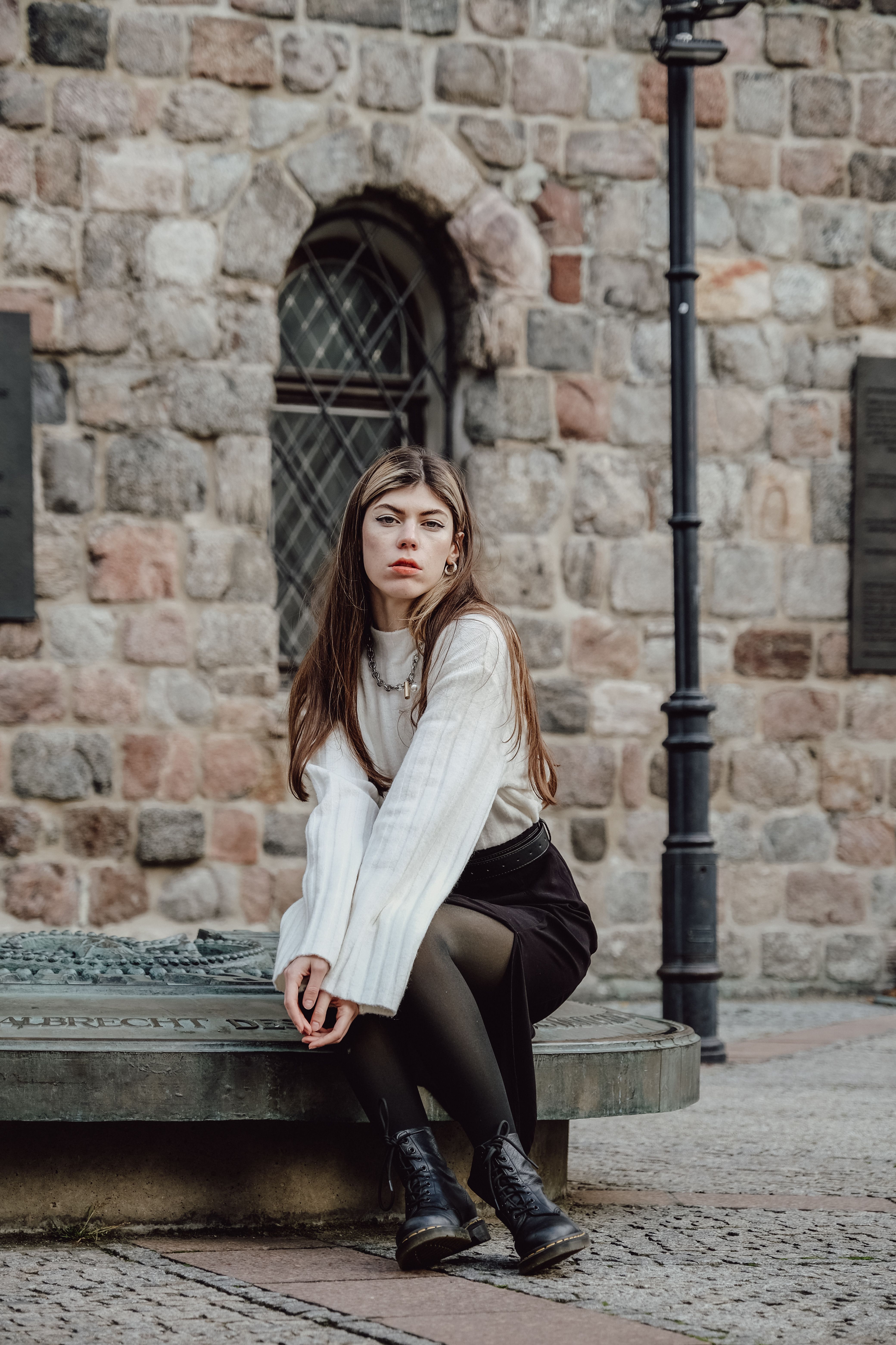 Woman in White Sweater Sitting on Plinth · Free Stock Photo