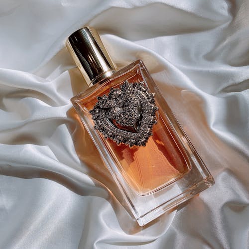 Decorative Bottle of Perfume Devotion from Dolce Gabbana on White Silk