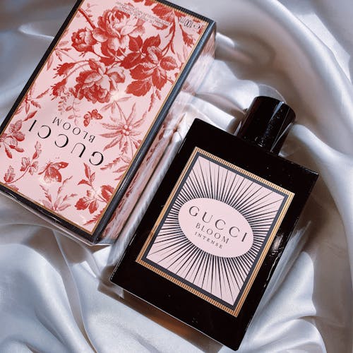 Bottle and Floral Box of Gucci Bloom Eau de Parfum Intense on a White Silk