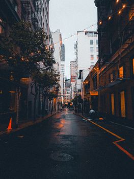A city alley illuminated by string lights, creating a moody urban atmosphere at night.