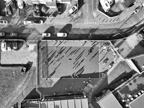 Aerial black and white photo capturing a playground in Central Bedfordshire, UK with people casting shadows.
