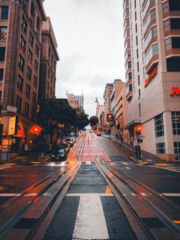 A vibrant city street in San Francisco with iconic uphill tracks and urban architecture.