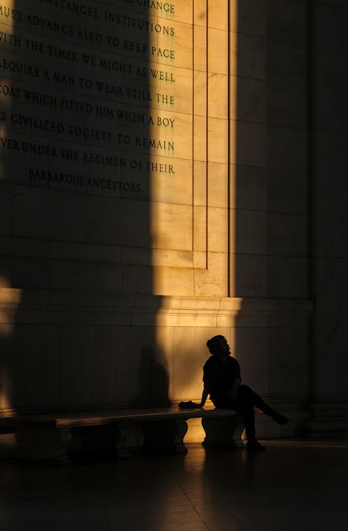 Man Sitting by Shadowed Inscription in Jefferson Memorial