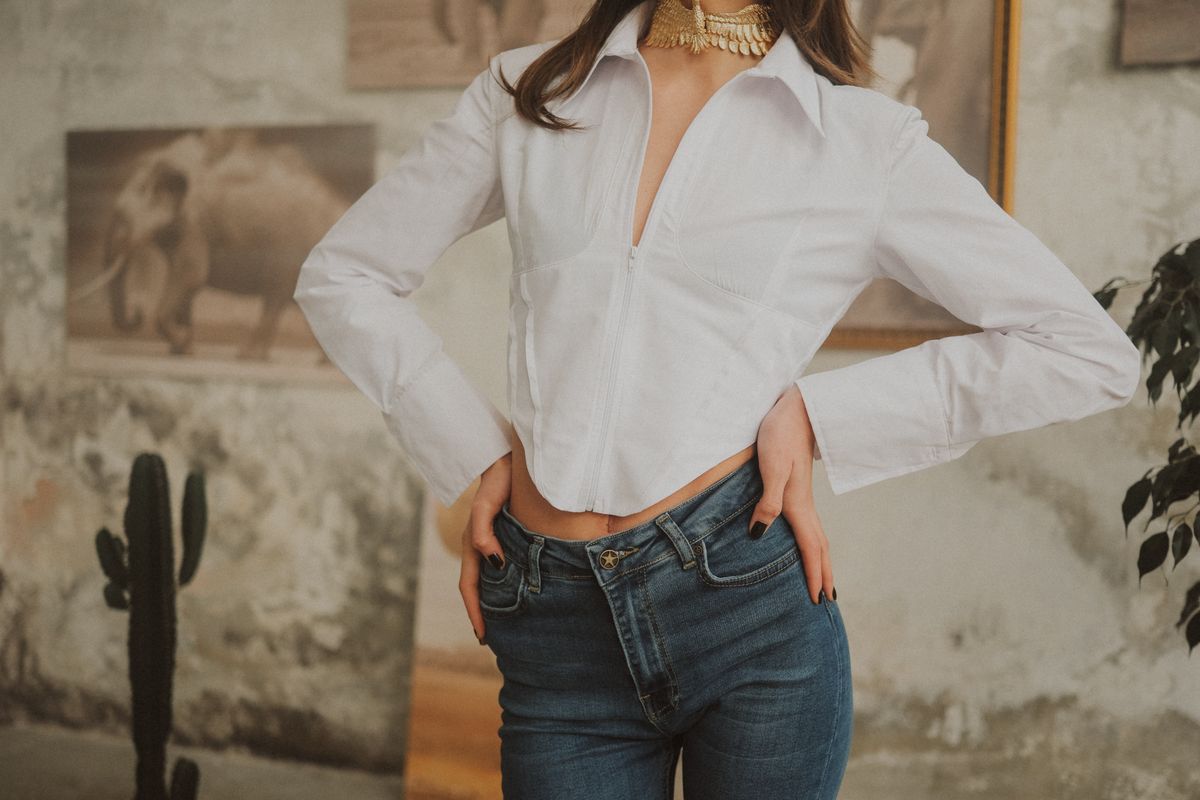 Woman styled in a white button-down shirt with jeans