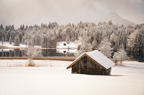 Wooden Cabin in the Snow by a Lake