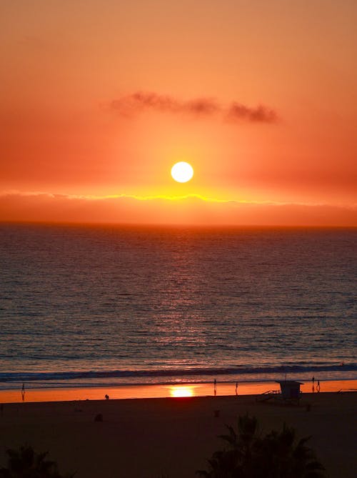 Sun Setting in Orange Sky over Calm Sea