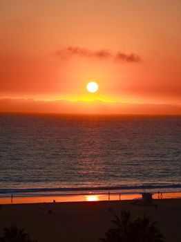 Beautiful sunset over the ocean at a Los Angeles beach, with vivid orange sky and reflections.
