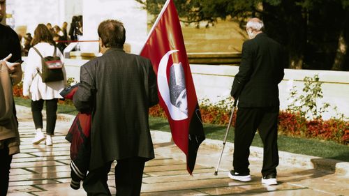 Free A group of people gathered outdoors with a Turkish flag. Urban setting with diverse crowd. Stock Photo