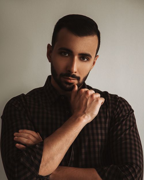 Free Portrait of a confident man in a checkered shirt with a thoughtful pose. Stock Photo