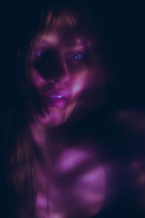 Free Ethereal portrait of a woman in soft purple lighting creating a mysterious atmosphere. Stock Photo