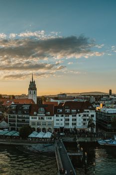 Beautiful aerial view of Friedrichshafen's waterfront during sunset with a vibrant cityscape.