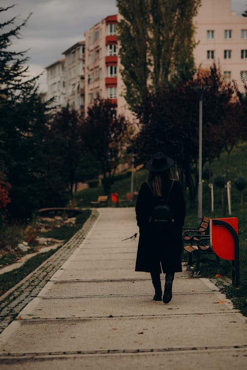 Back View of a Woman Walking on a Pavement in City