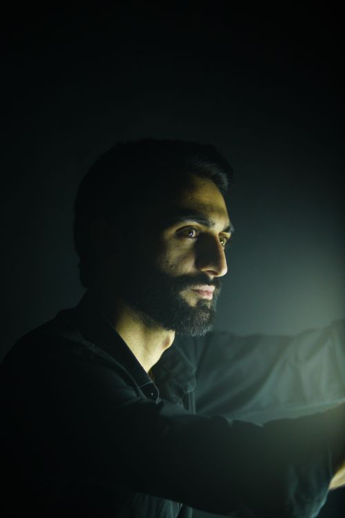 Free Dramatic portrait of a man with beard illuminated in dark setting. Stock Photo