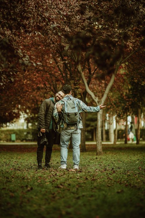 Free Two friends enjoying a walk in a park during autumn, surrounded by colorful fall foliage. Stock Photo